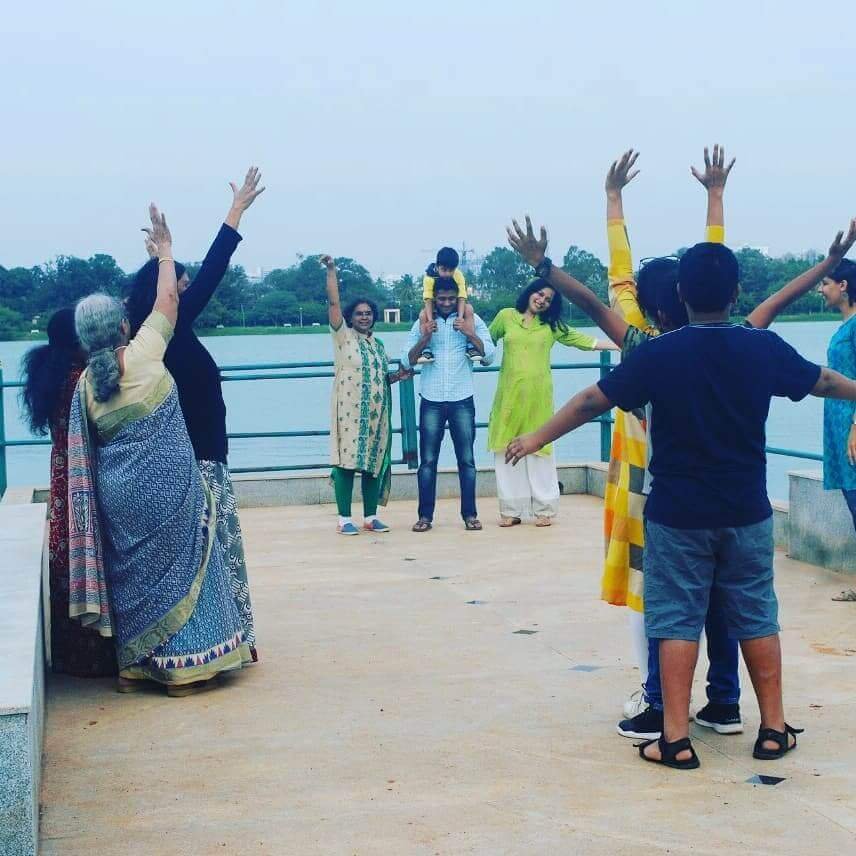 Participants with arms raised in an outdoor community workshop